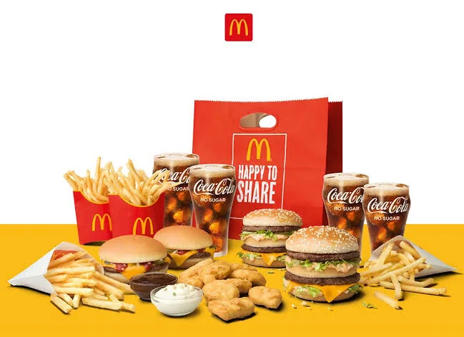 Shareable meal spread with burgers, fries, nuggets, dipping sauces, and drinks